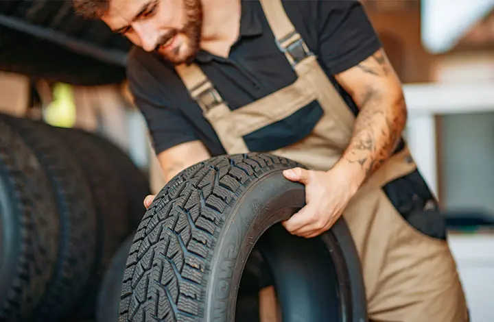 Mitarbeiter im Reifenservice mit Autoreifen